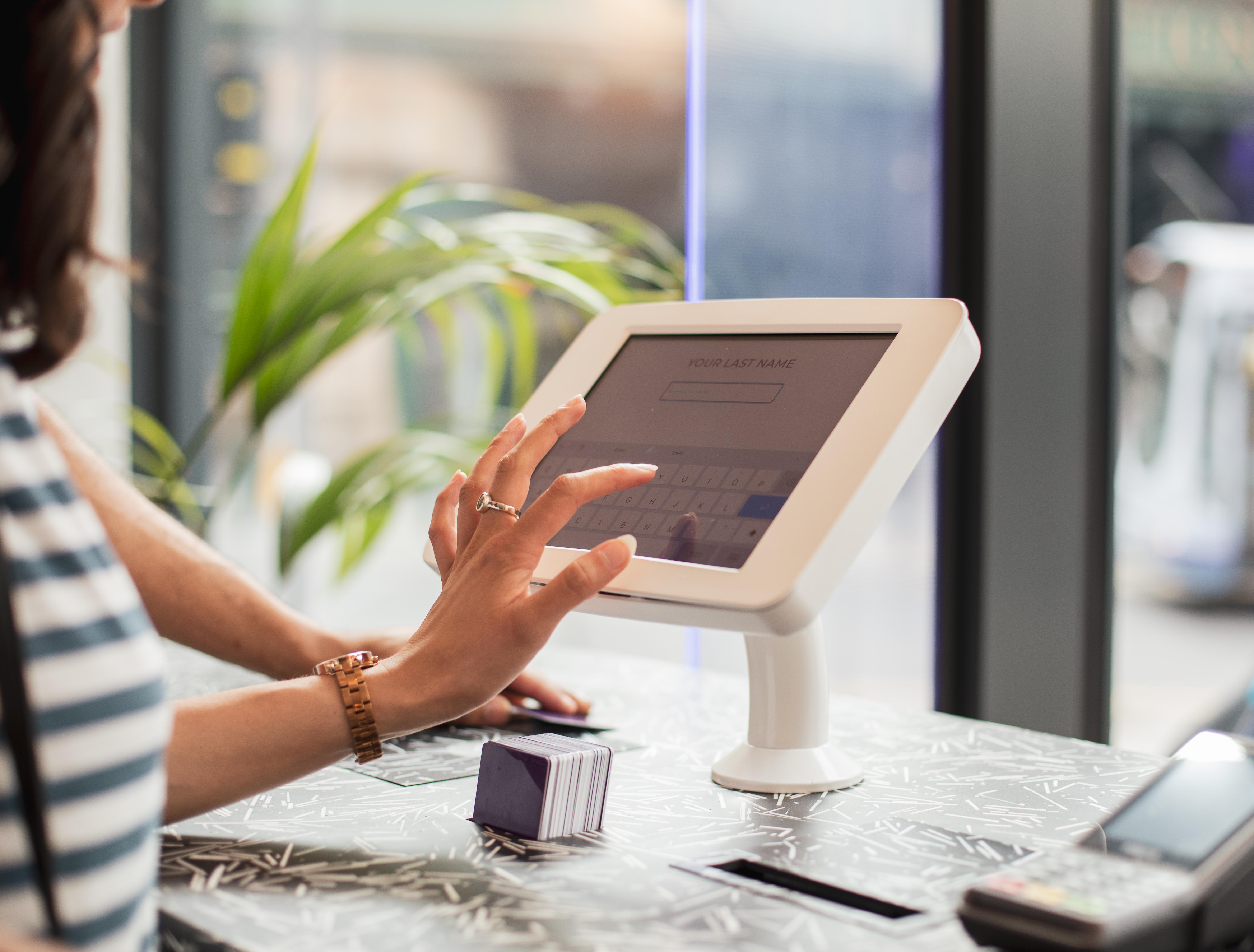 Yotel Glasgow Exteriér fotografie A woman using a tablet to enter her name at a check-in desk